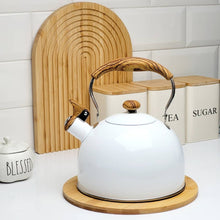 Load image into Gallery viewer, White kettle with wooden handle on a wooden trivet, with tea and sugar containers in the background.
