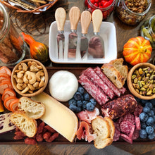 تحميل الصورة في عارض المعرض، Cheese knives set with wooden handles displayed on a charcuterie board with assorted cheeses, meats, and fruits.
