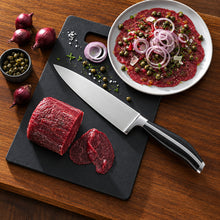 تحميل الصورة في عارض المعرض، Raw beef with sliced pieces on a cutting board, a knife, and a plate of prepared beef dish on a wooden surface.
