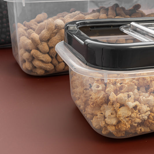 Two containers of pet food on a brown surface.