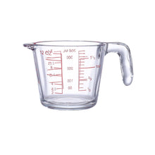 تحميل الصورة في عارض المعرض، Clear glass measuring cup with red measurement markings on a white background
