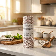 Load image into Gallery viewer, A roll of hand-torn rag paper branded YUN YANG, featuring a white paper label with black text and a red geometric pattern wrapping the top and bottom of the roll, set against a plain white background.
