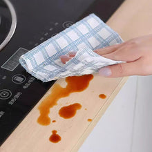 Load image into Gallery viewer, Hand using a checkered cloth to wipe up a spill on a stovetop.

