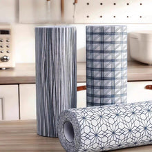 Load image into Gallery viewer, Three rolls of patterned vinyl flooring in a kitchen setting.
