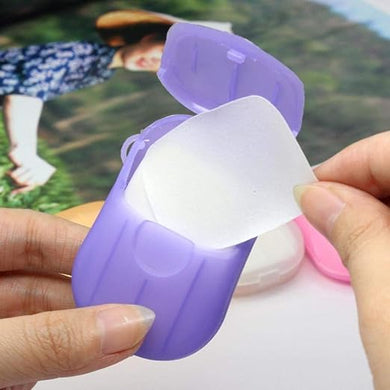 Purple and white container with a light inside, held by hands against a blurred background.