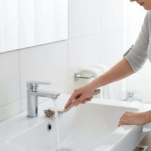 Load image into Gallery viewer, Person cleaning a sink with a brush in a bathroom setting
