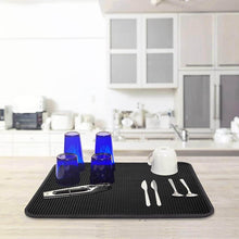 Load image into Gallery viewer, Black mat with blue cups, white mug, and silverware on a kitchen counter.

