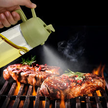 تحميل الصورة في عارض المعرض، A hand holds a translucent olive oil spray bottle over two grilled steaks on a black grill grate with visible flames and smoke against a dark background.
