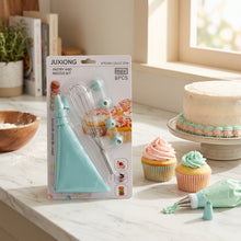 Load image into Gallery viewer, Juxiong pastry and nozzle set in a blister pack, featuring a light blue piping bag, metal whisk, and three nozzle tips, displayed against a blurred outdoor background with a wooden table.
