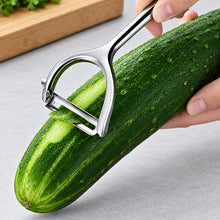 تحميل الصورة في عارض المعرض، Cucumber being sliced with a vegetable peeler on a gray surface, with 'HOMGED' branding visible.
