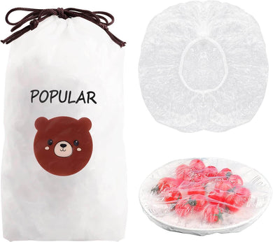 Plastic food storage covers in a bag with a cute bear design, showing covers and a plate of strawberries.
