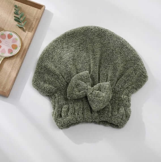 Green towel with a bow on a white surface