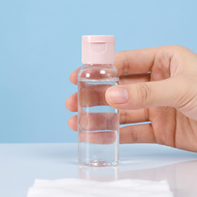 Load image into Gallery viewer, Hand holding a refillable mini container with clear liquid, perfect for travel or toiletries.
