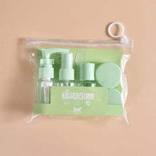 Load image into Gallery viewer, Set of green travel-sized bottles and accessories in a clear pouch on a beige background
