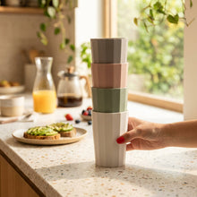 Load image into Gallery viewer, Stack of three colorful cups held by a hand against a pink background
