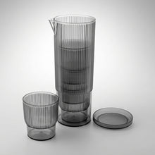 تحميل الصورة في عارض المعرض، Set of gray glass pitcher, tumblers, and lid on a light gray background
