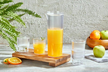 Load image into Gallery viewer, Clear carafe with orange juice on a wooden tray with glasses, surrounded by fruits and a plant.
