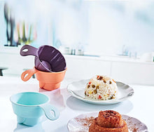 Load image into Gallery viewer, Colorful silicone measuring cups on a kitchen counter with a plate of food in the background.
