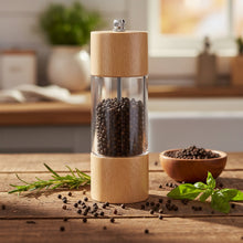 Load image into Gallery viewer, Two wooden pepper mills with clear glass bodies on a white background
