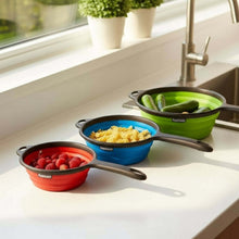 تحميل الصورة في عارض المعرض، Collapsible silicone bowls in red, blue, and green on a kitchen counter with vegetables.

