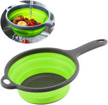 تحميل الصورة في عارض المعرض، Collapsible green colander with gray handle being used to drain fruits into a sink.
