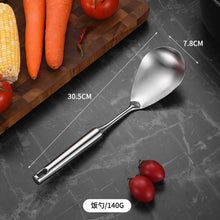 تحميل الصورة في عارض المعرض، A stainless steel spoon with a long handle, displayed on a dark surface with vegetables in the background.
