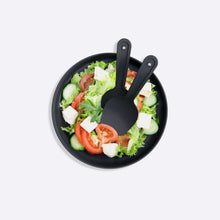 Load image into Gallery viewer, Black plate with a salad and two black spoons on a white background
