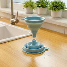Load image into Gallery viewer, Collapsible silicone funnel on a kitchen counter with plants in the background
