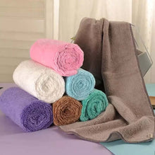 Load image into Gallery viewer, Stack of rolled-up towels in various colors on a surface with a neutral background.
