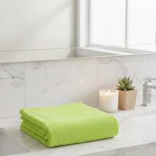 Load image into Gallery viewer, Green towel on a kitchen counter with a candle and plant in the background
