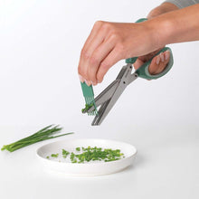 Load image into Gallery viewer, Person using kitchen shears to chop green onions on a white plate with a white background
