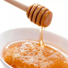 تحميل الصورة في عارض المعرض، Honey being dripped from a wooden honey dipper into a white bowl.
