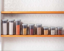 Load image into Gallery viewer, Row of food containers on a wooden pantry shelf
