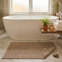Load image into Gallery viewer, Brown bath mat with a textured pattern on a white background
