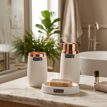 Load image into Gallery viewer, A set of three bathroom accessories with copper frame and white stripes, including a liquid soap dispenser, a toothbrush and paste cup, and a dry soap dispenser, all branded with 'Okyanus'.
