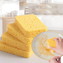 Load image into Gallery viewer, A stack of yellow cellulose sponges, with one being used to clean a glass plate.
